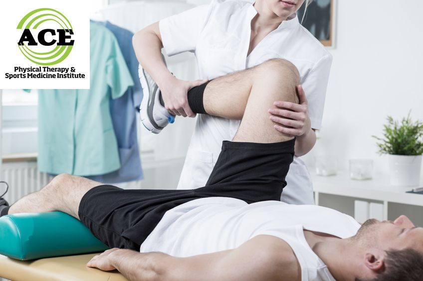 42784446 - female physiotherapist training leg of young man