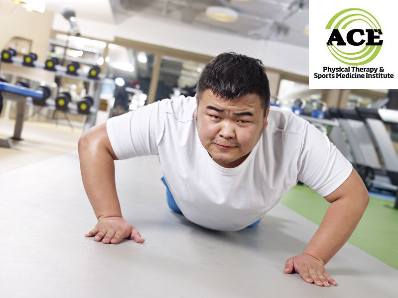 24461735 - an overweight young man doing push-ups with sweating face